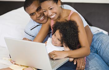 family looking at laptop computer 